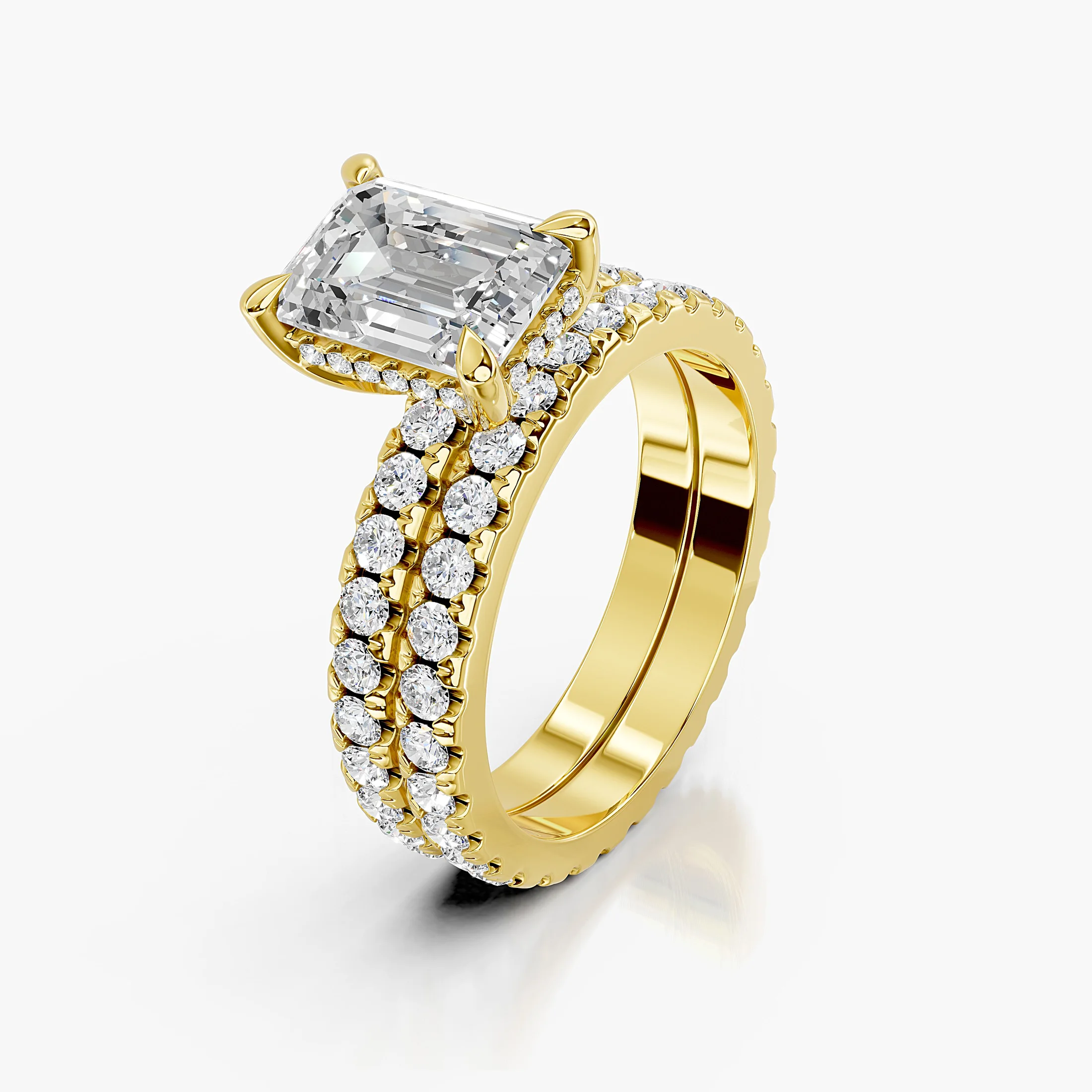 Emerald center engagement ring with hidden halo, round side stones, and straight coordinating diamond wedding band