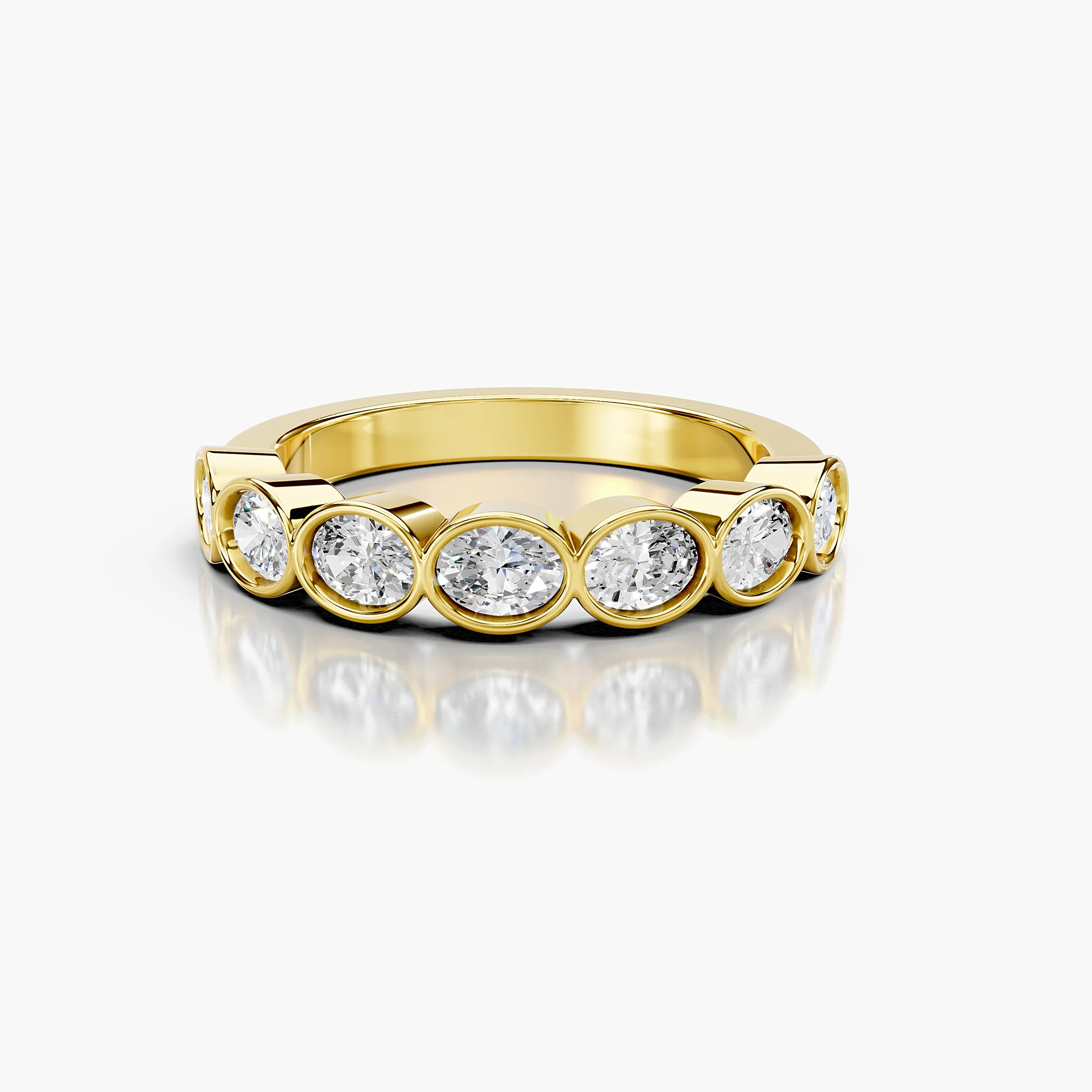 Wedding band featuring bezel-set oval diamonds arranged across a polished gold band.