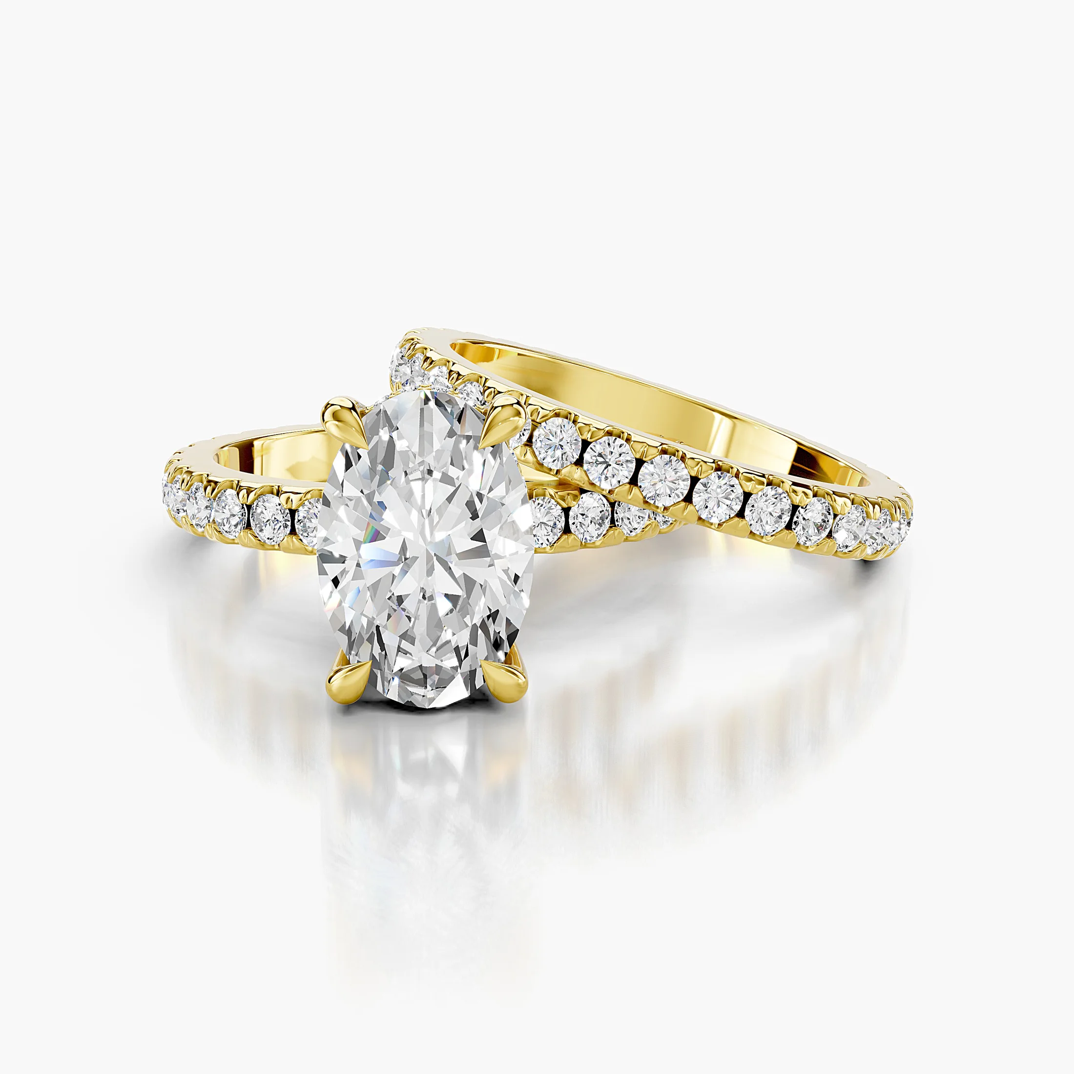 Oval diamond hidden halo engagement ring with round side stones and a straight coordinating diamond wedding band