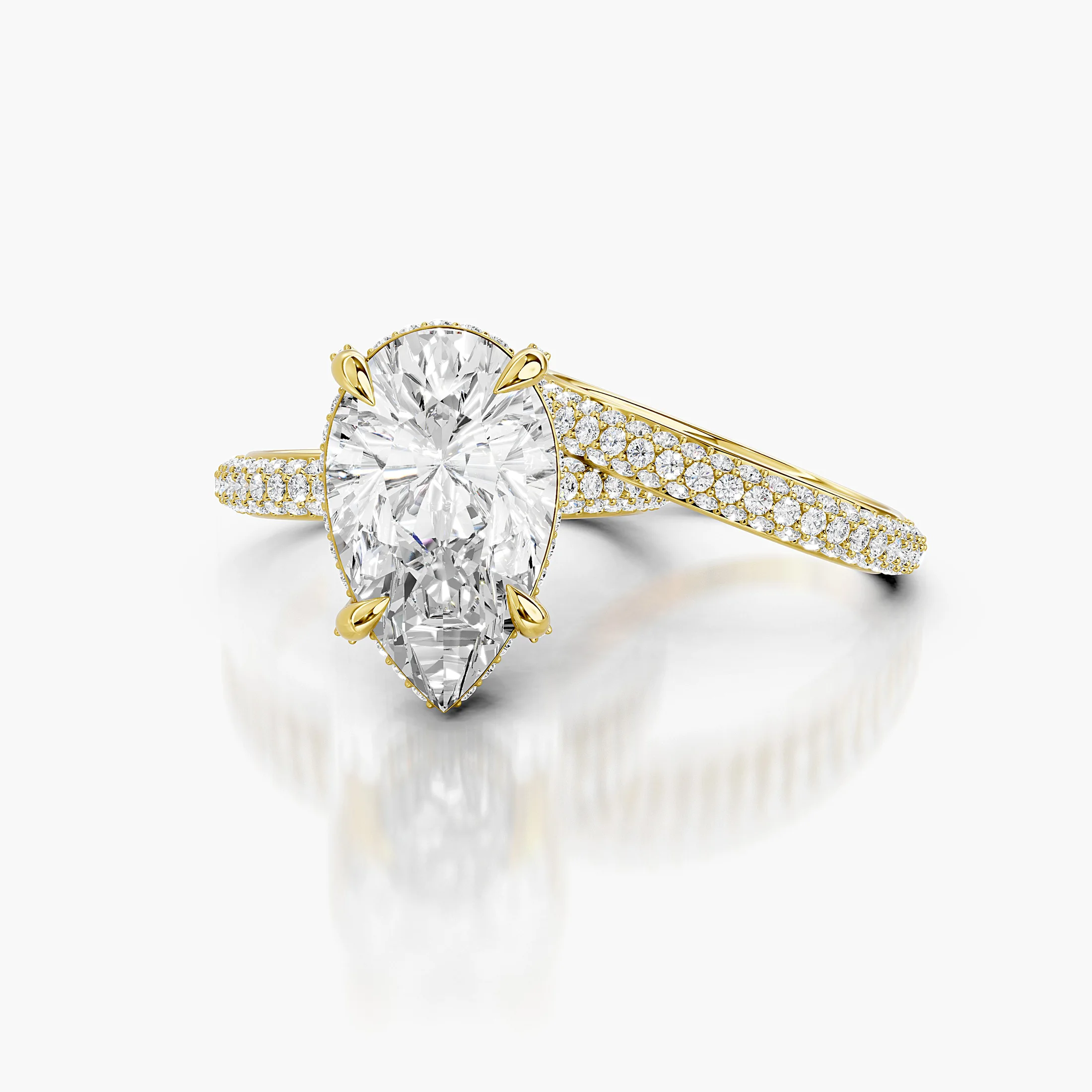 Pear-shaped center in a four-prong hidden-halo bridal set with round pavé shanks and a straight coordinating diamond band.