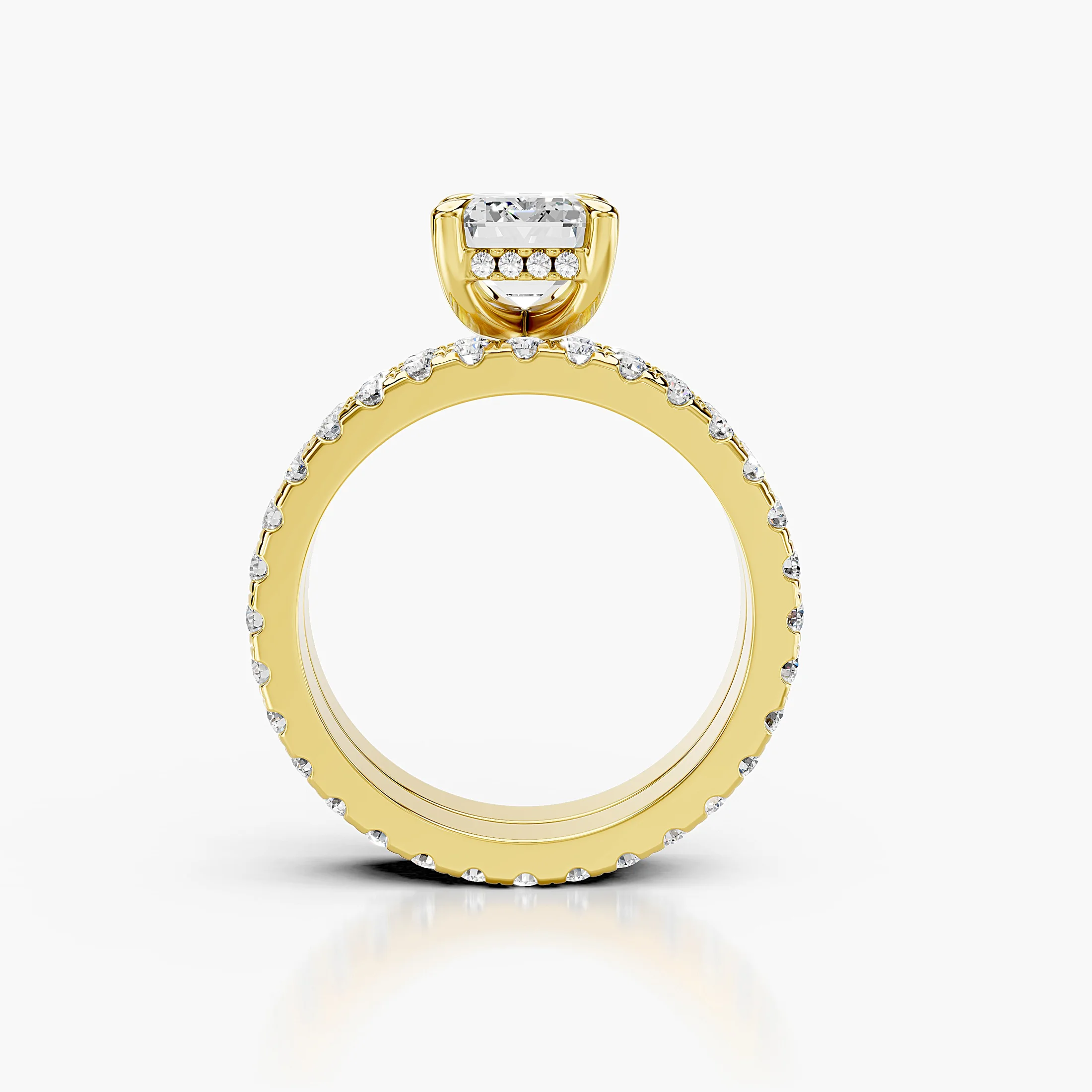 Emerald center engagement ring with hidden halo, round side stones, and straight coordinating diamond wedding band