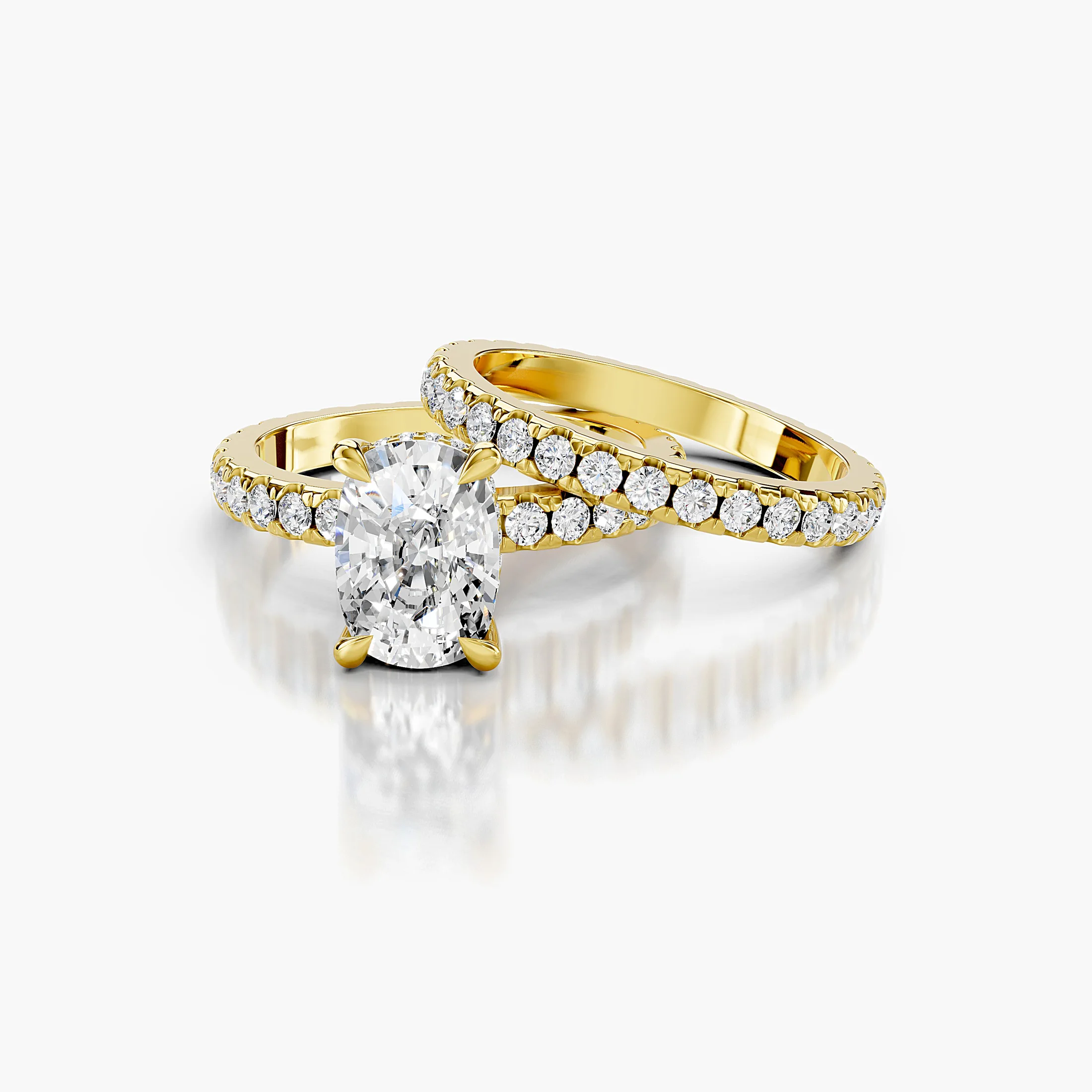 Cushion-shaped engagement ring with hidden halo, diamond-accented shoulders, and straight coordinating wedding band