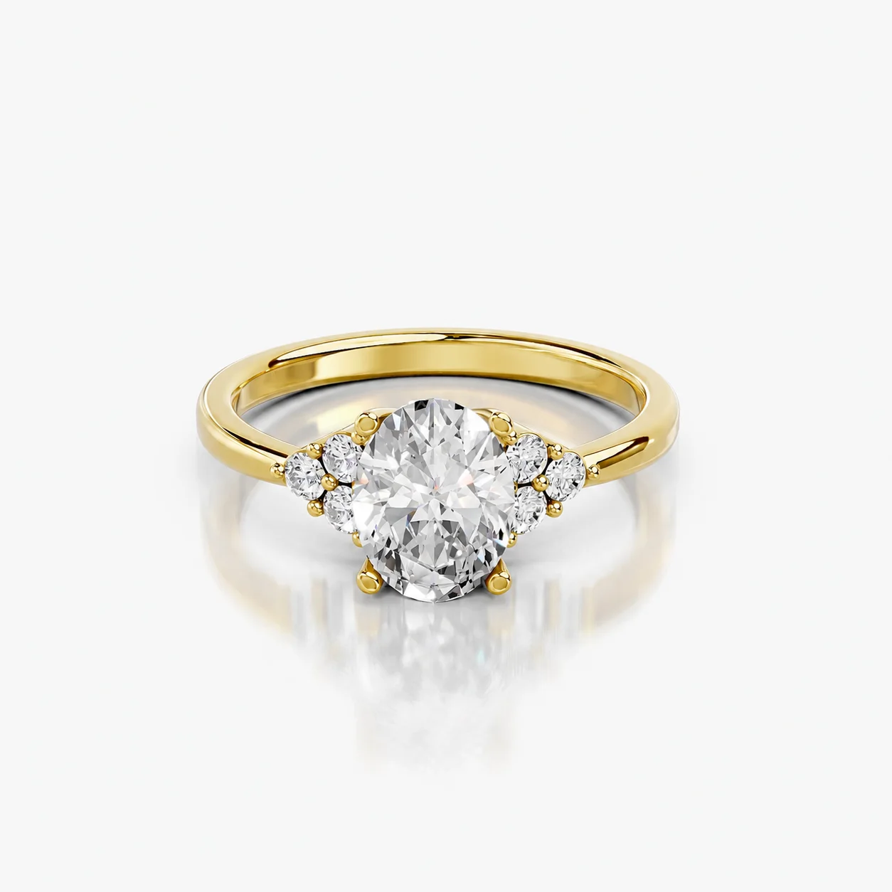 Oval four-prong engagement ring with three clustered round side stones on each shoulder and a polished tapered band.