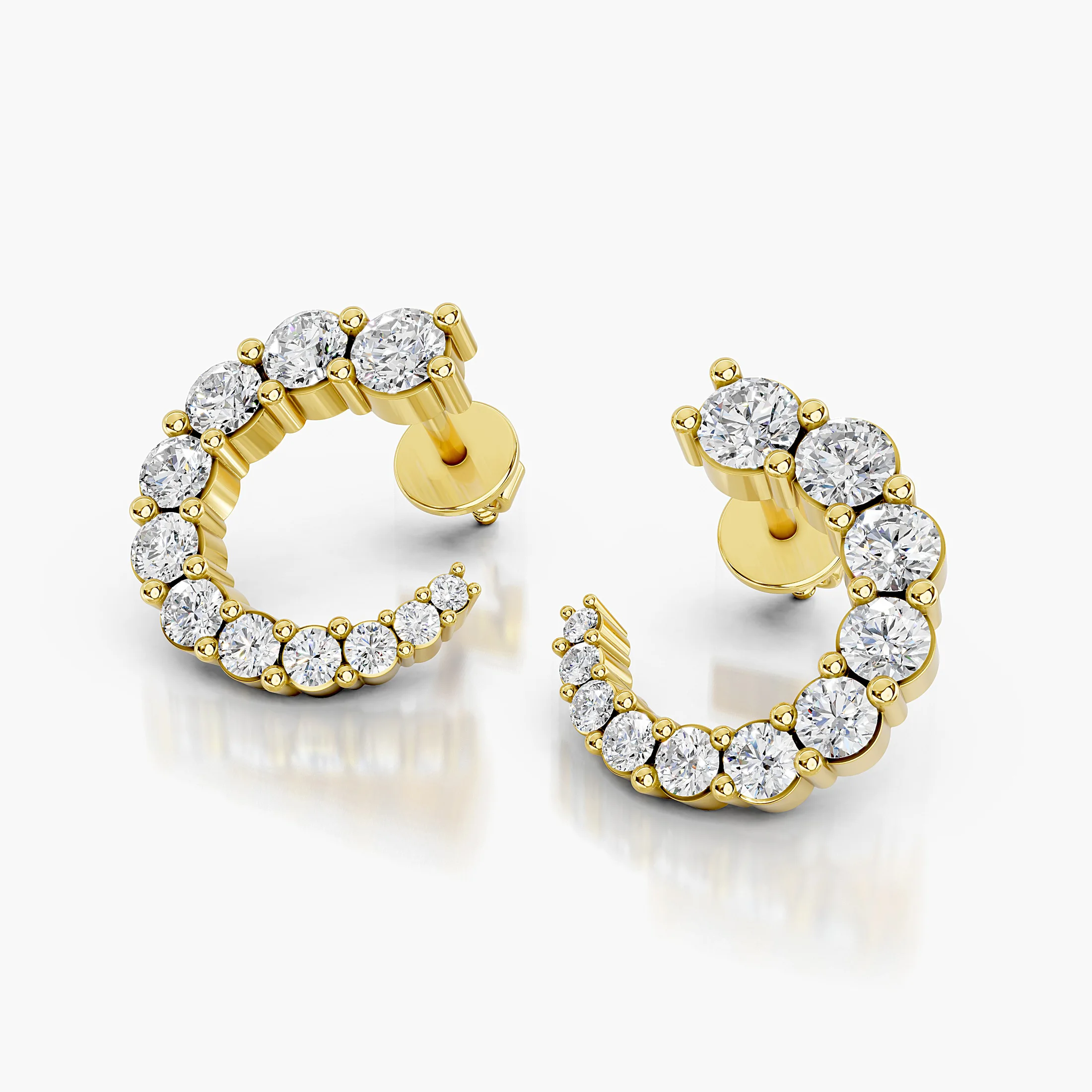 Pair of open C-shaped earrings with graduated round diamonds in prong settings