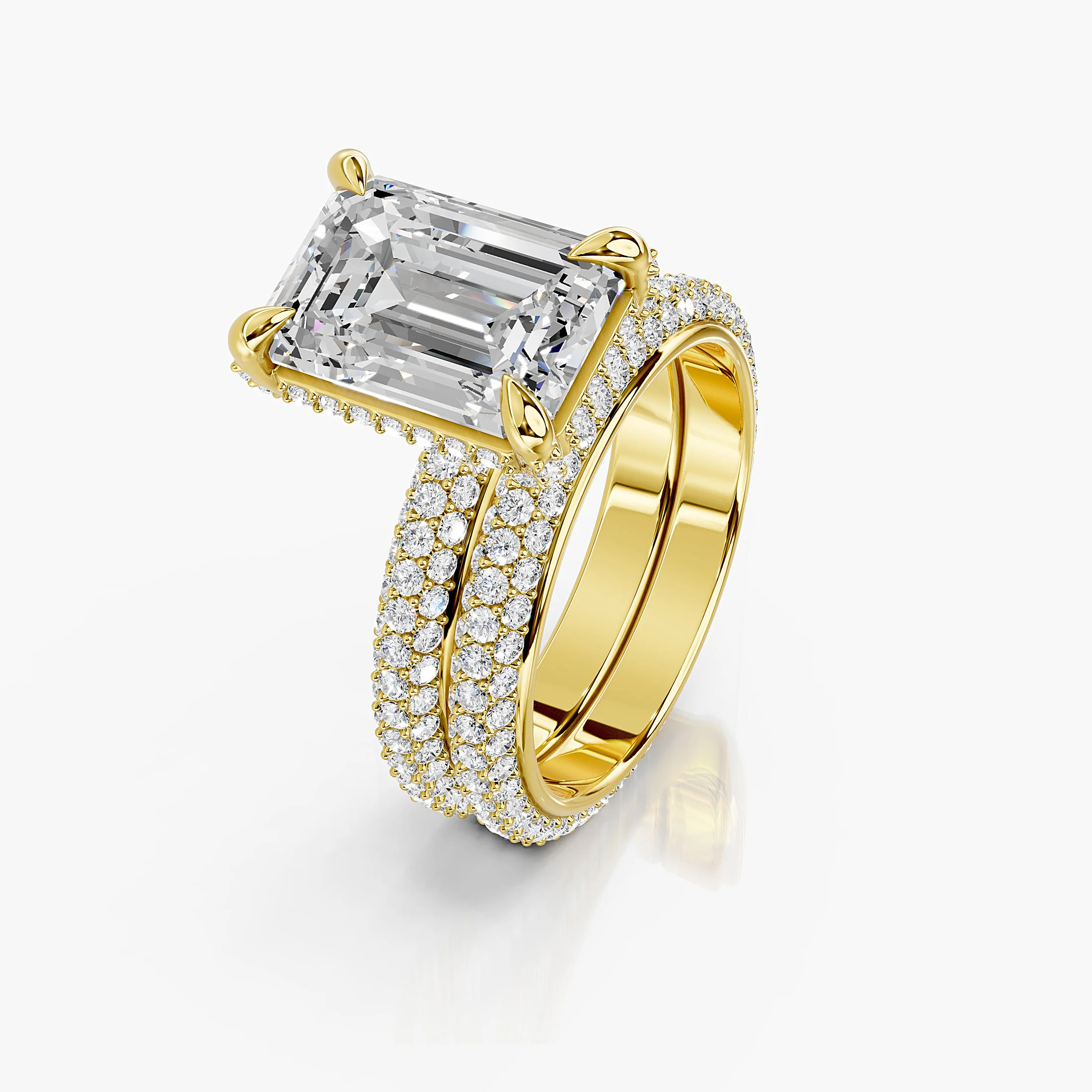 Two-piece bridal set featuring an emerald-cut center stone in a pavé-set diamond band.