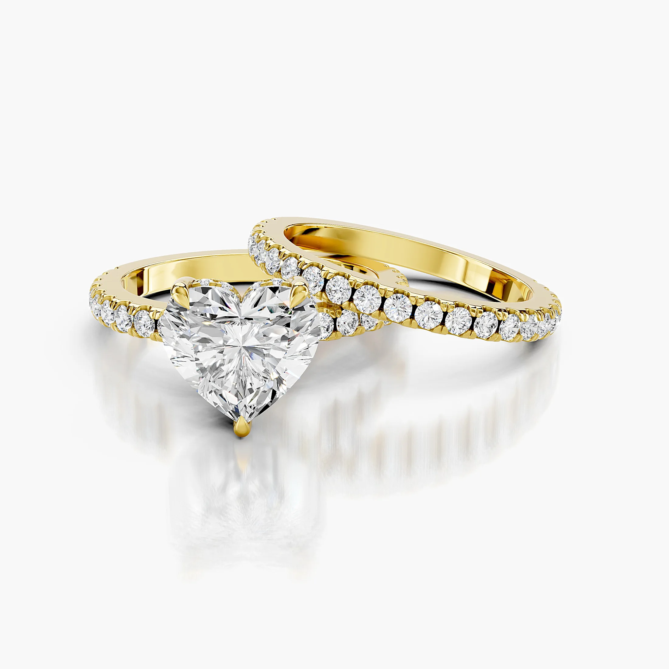 Heart-shaped engagement ring with hidden halo, round side stones, and straight coordinating diamond wedding band
