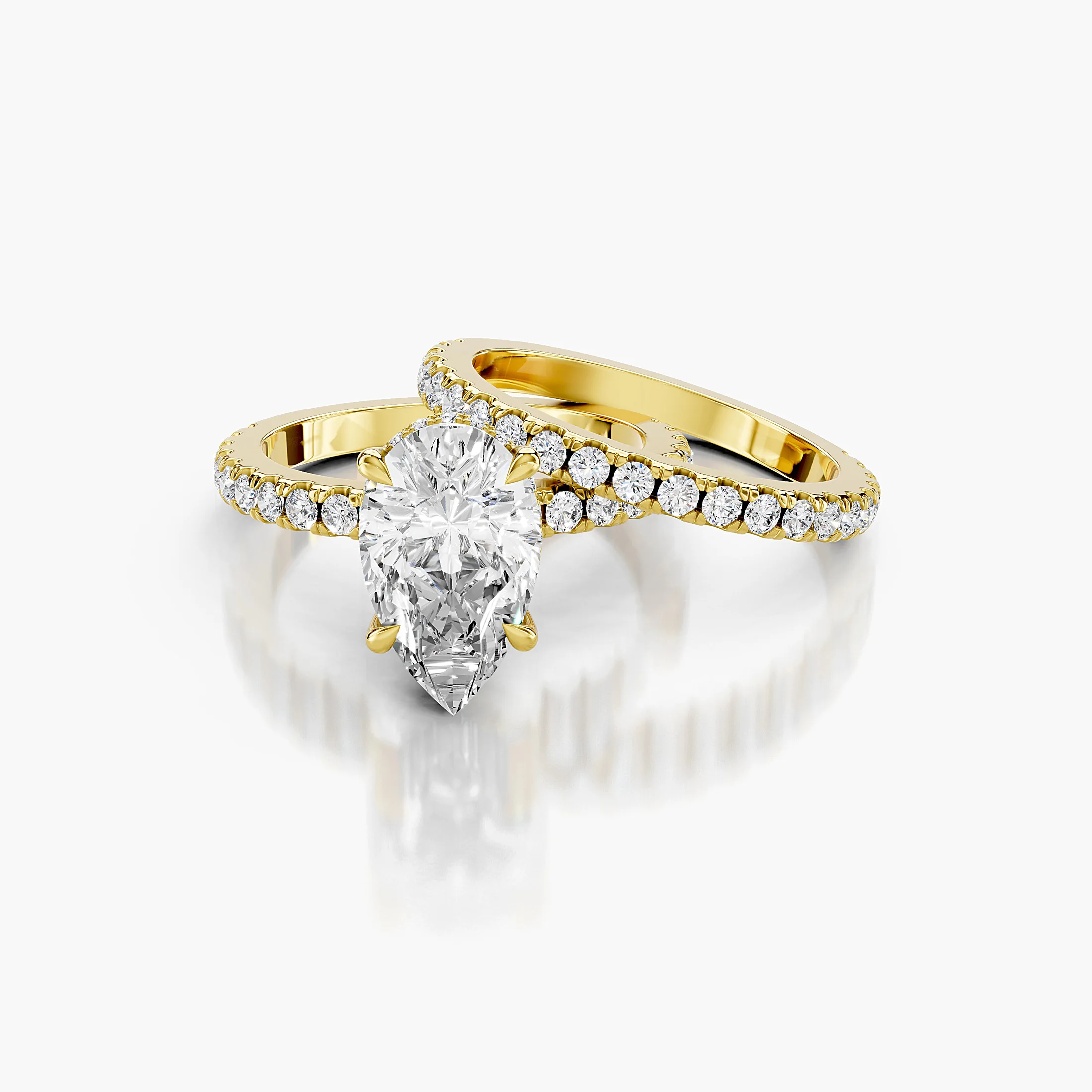 Pear-shaped hidden halo side-stone engagement ring with a coordinating straight diamond band shown as a two-piece bridal set