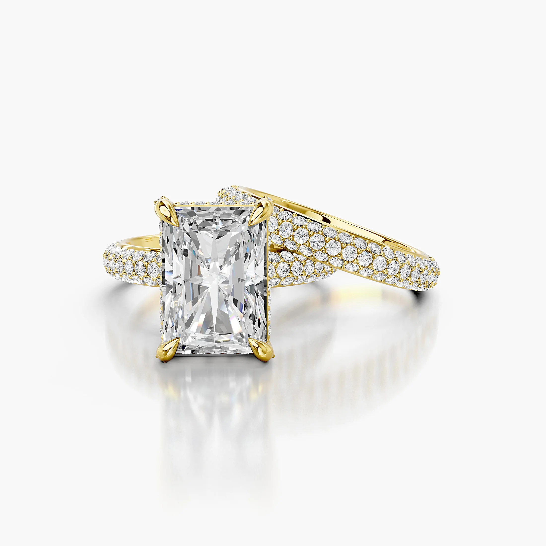 Solenne two-piece bridal ring set with an elongated radiant center, four-prong hidden-halo setting, multi-row round pavé, and straight coordinating band.