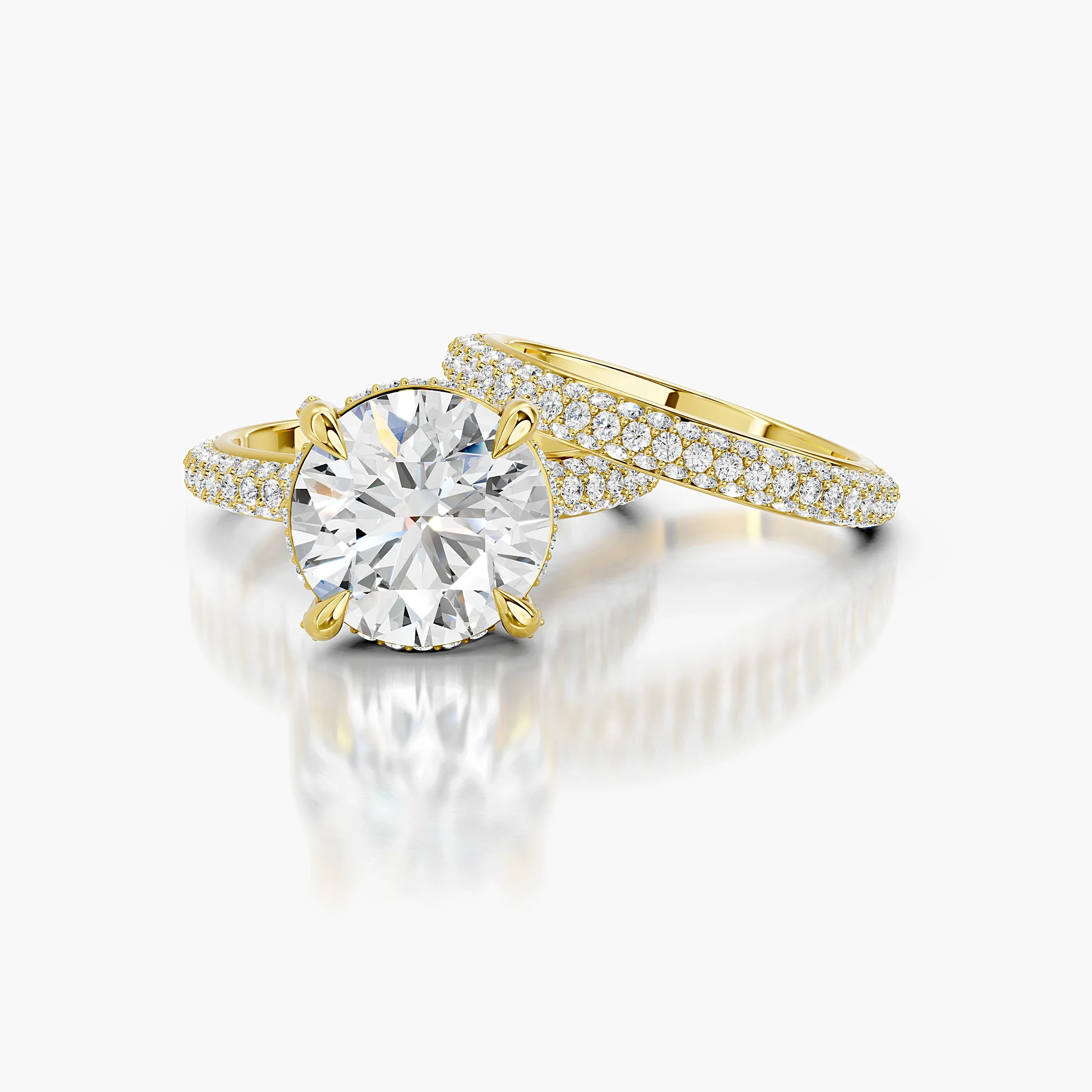 Elaris two-piece bridal ring set with a round center, raised four-prong hidden-halo setting, multi-row pavé shank, and straight coordinating band.