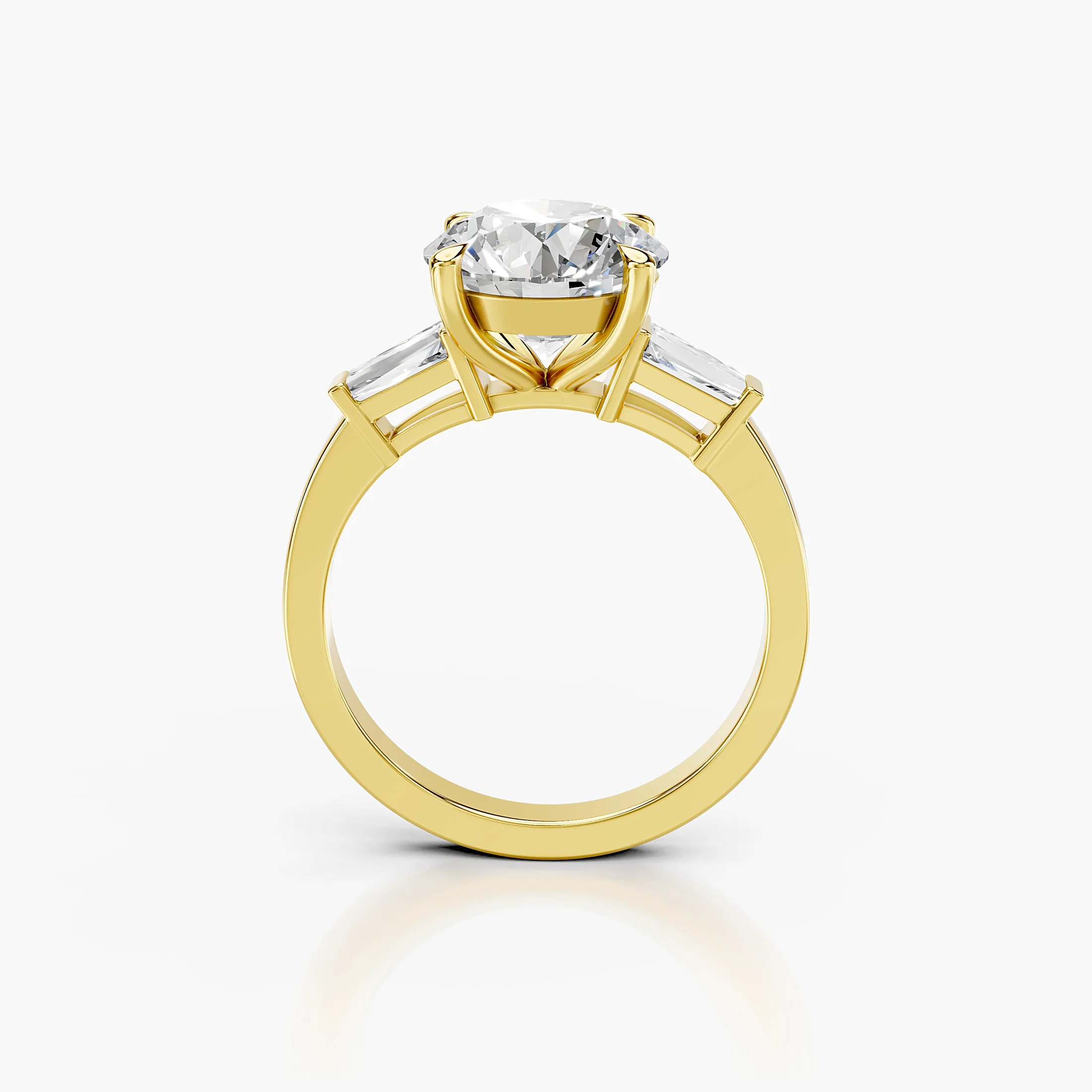 Three-stone engagement ring featuring a round center diamond flanked by tapered baguette diamonds.