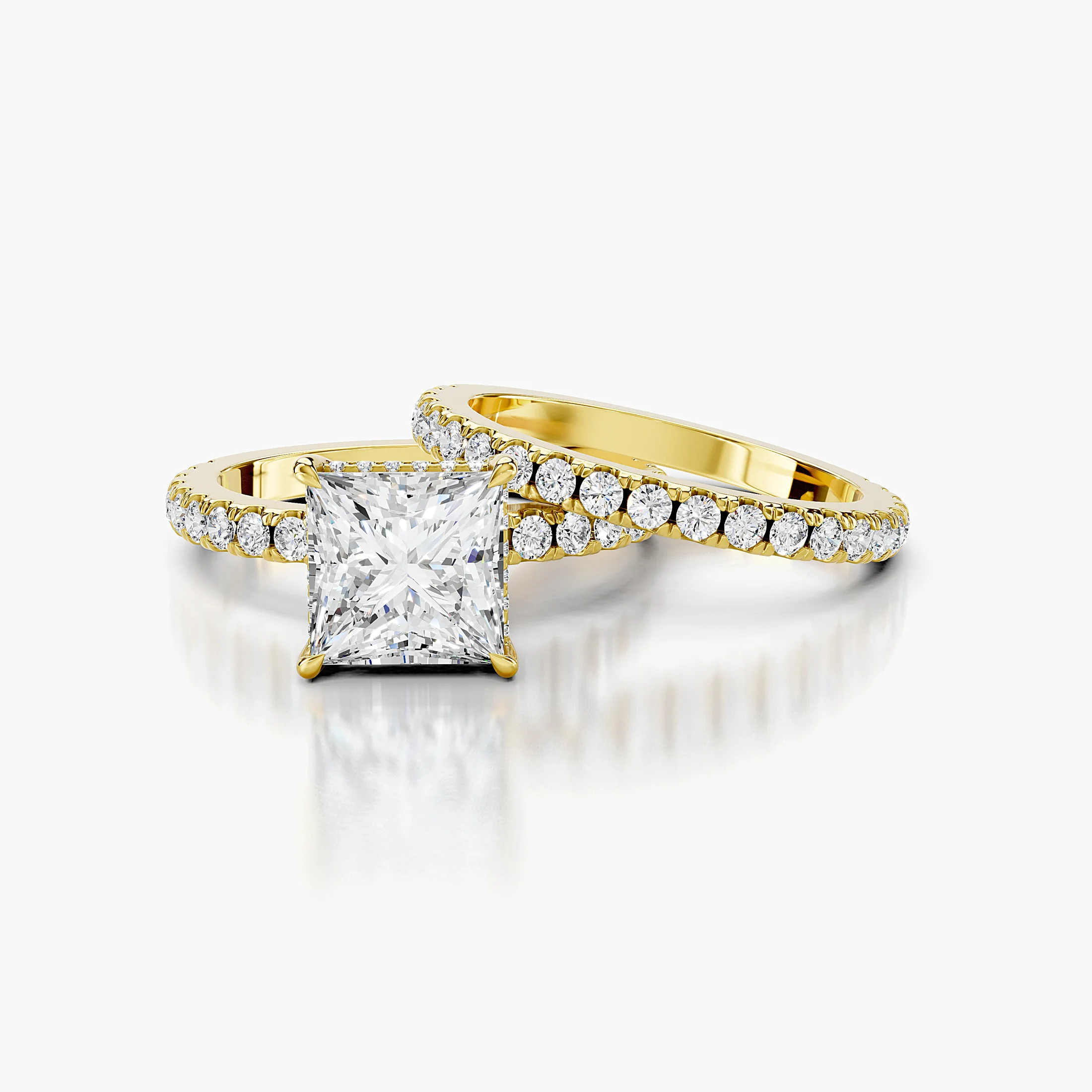 Princess-cut hidden halo side-stone engagement ring with a coordinating straight diamond band shown as a two-piece bridal set
