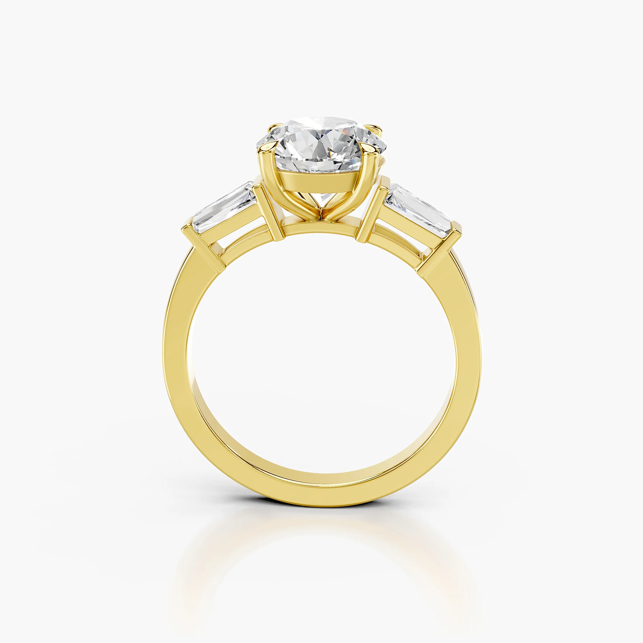 Three-stone engagement ring featuring a round center diamond flanked by tapered baguette diamonds.