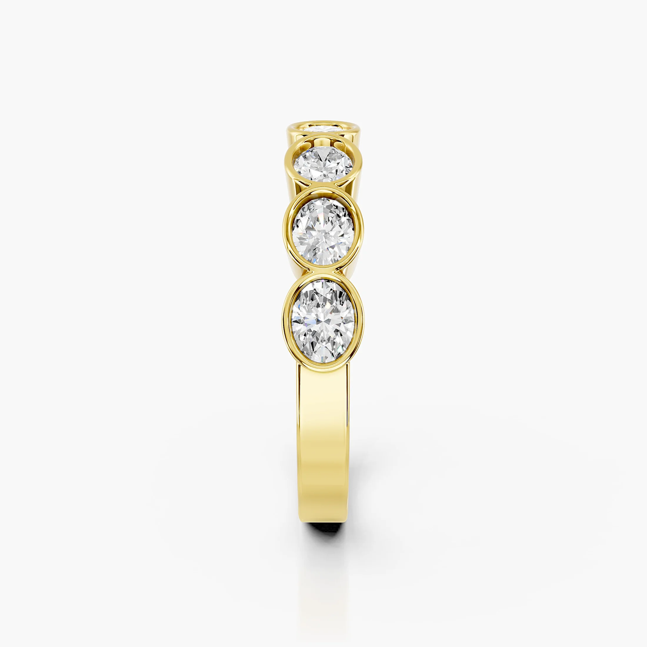 Wedding band featuring bezel-set oval diamonds arranged across a polished gold band.
