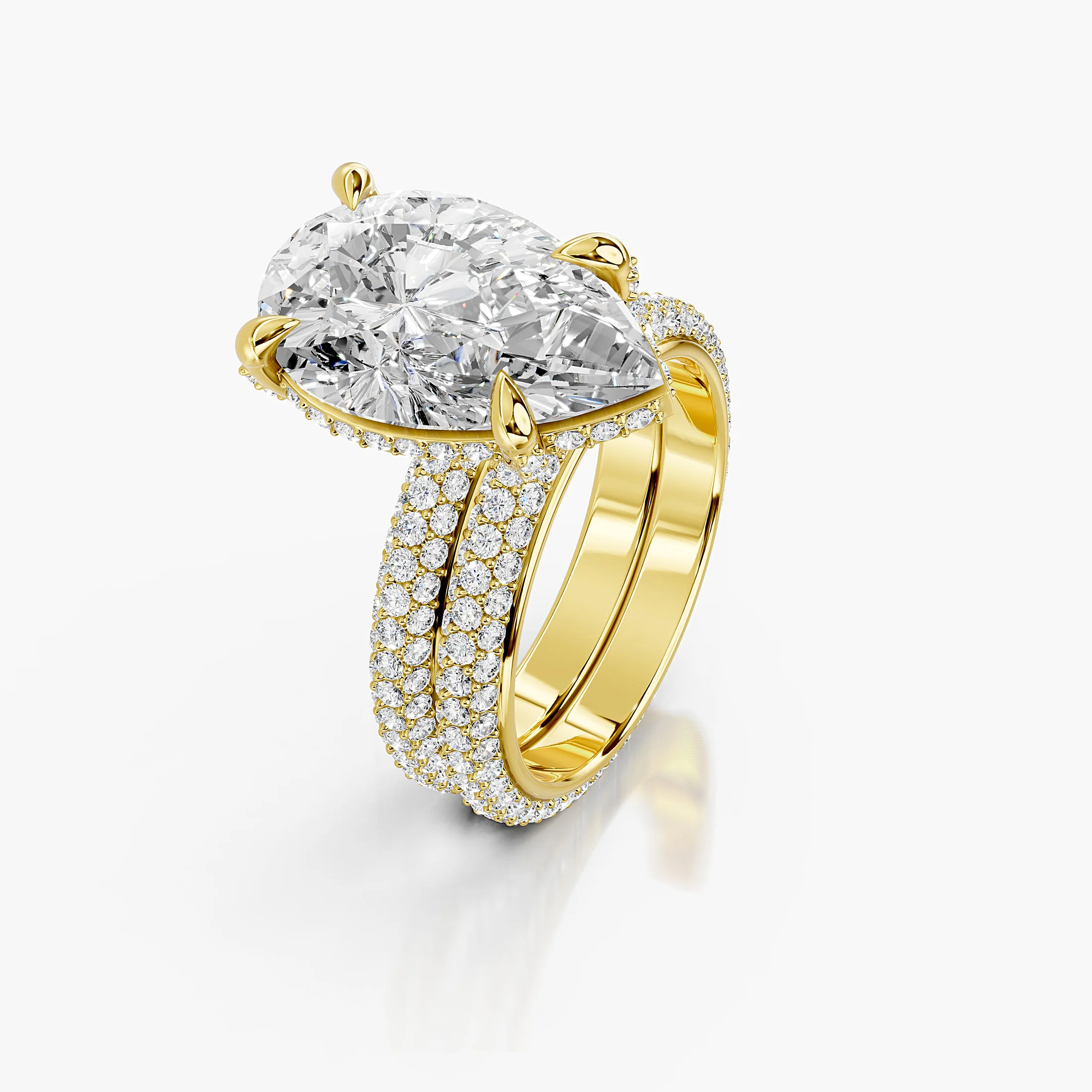 Pear-shaped center in a four-prong hidden-halo bridal set with round pavé shanks and a straight coordinating diamond band.