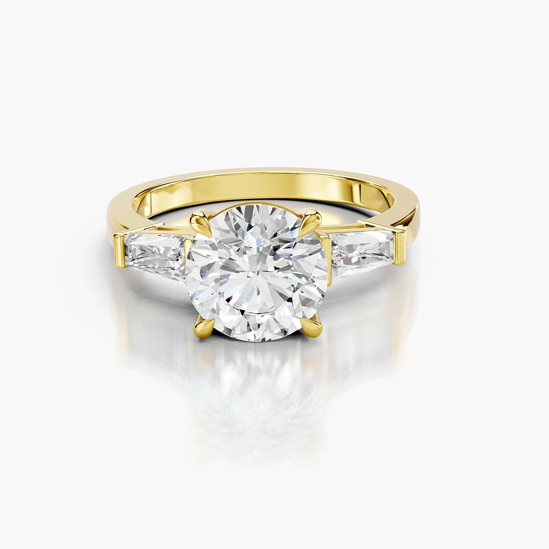 Three-stone engagement ring featuring a round center diamond flanked by tapered baguette diamonds.