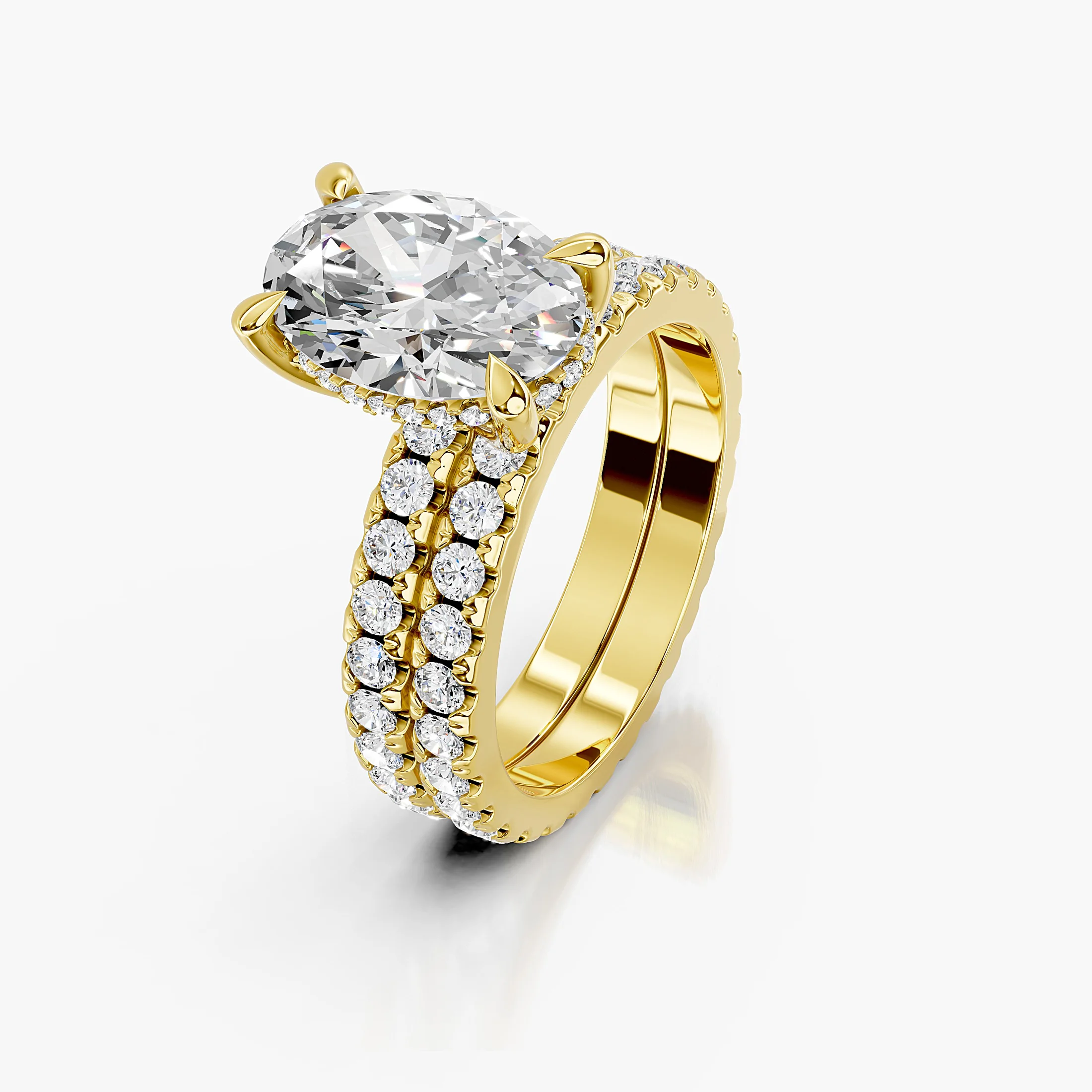 Oval diamond hidden halo engagement ring with round side stones and a straight coordinating diamond wedding band