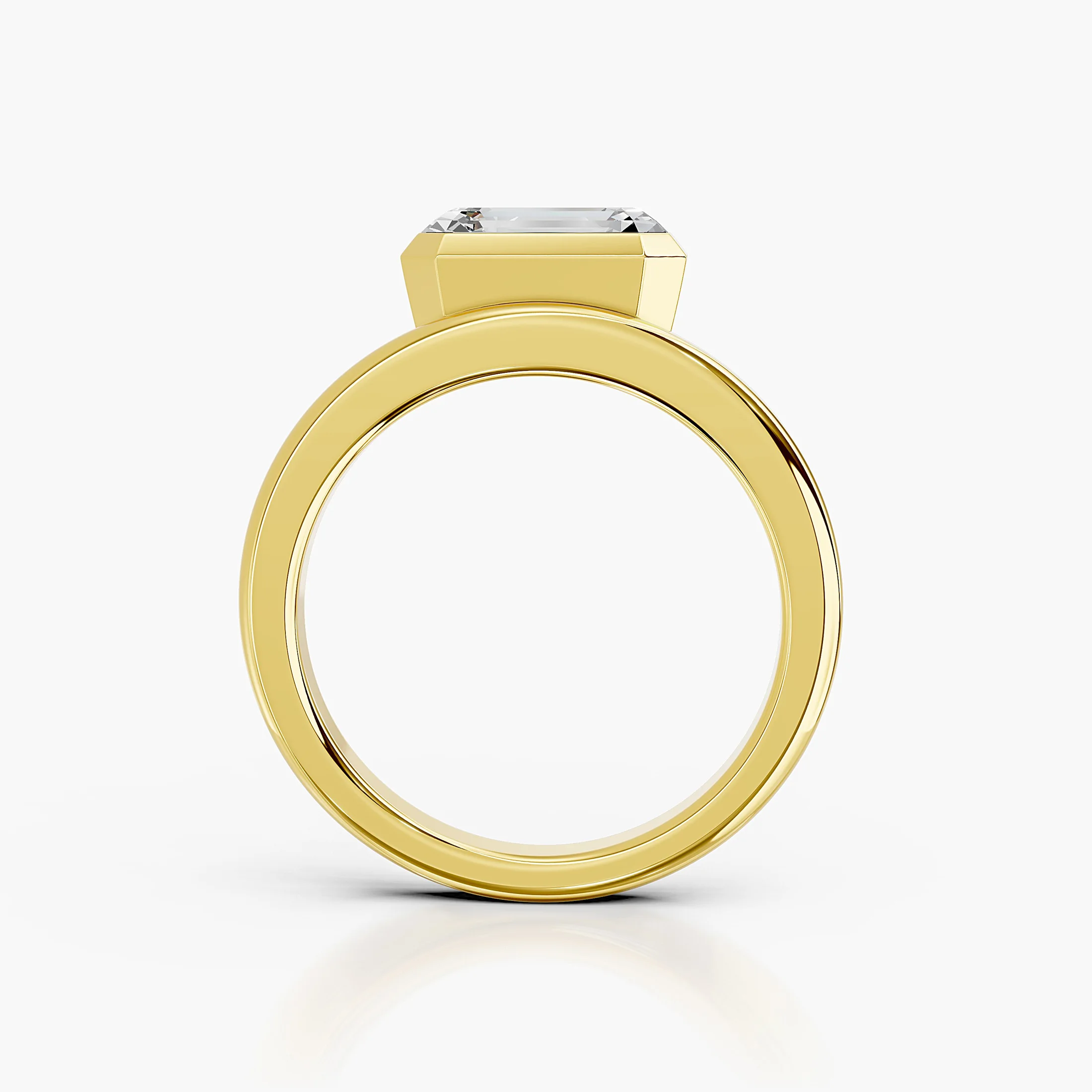 Emerald-cut diamond solitaire ring set in a bold bezel on a wide polished band.