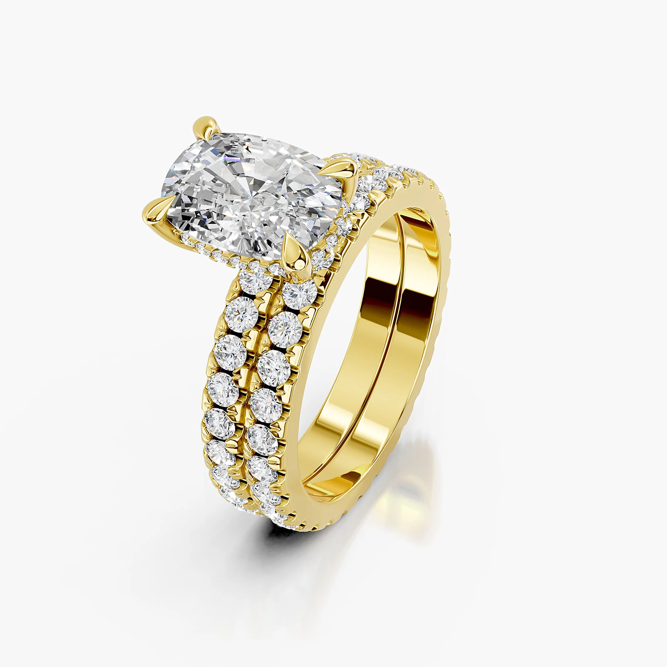 Cushion-shaped engagement ring with hidden halo, diamond-accented shoulders, and straight coordinating wedding band