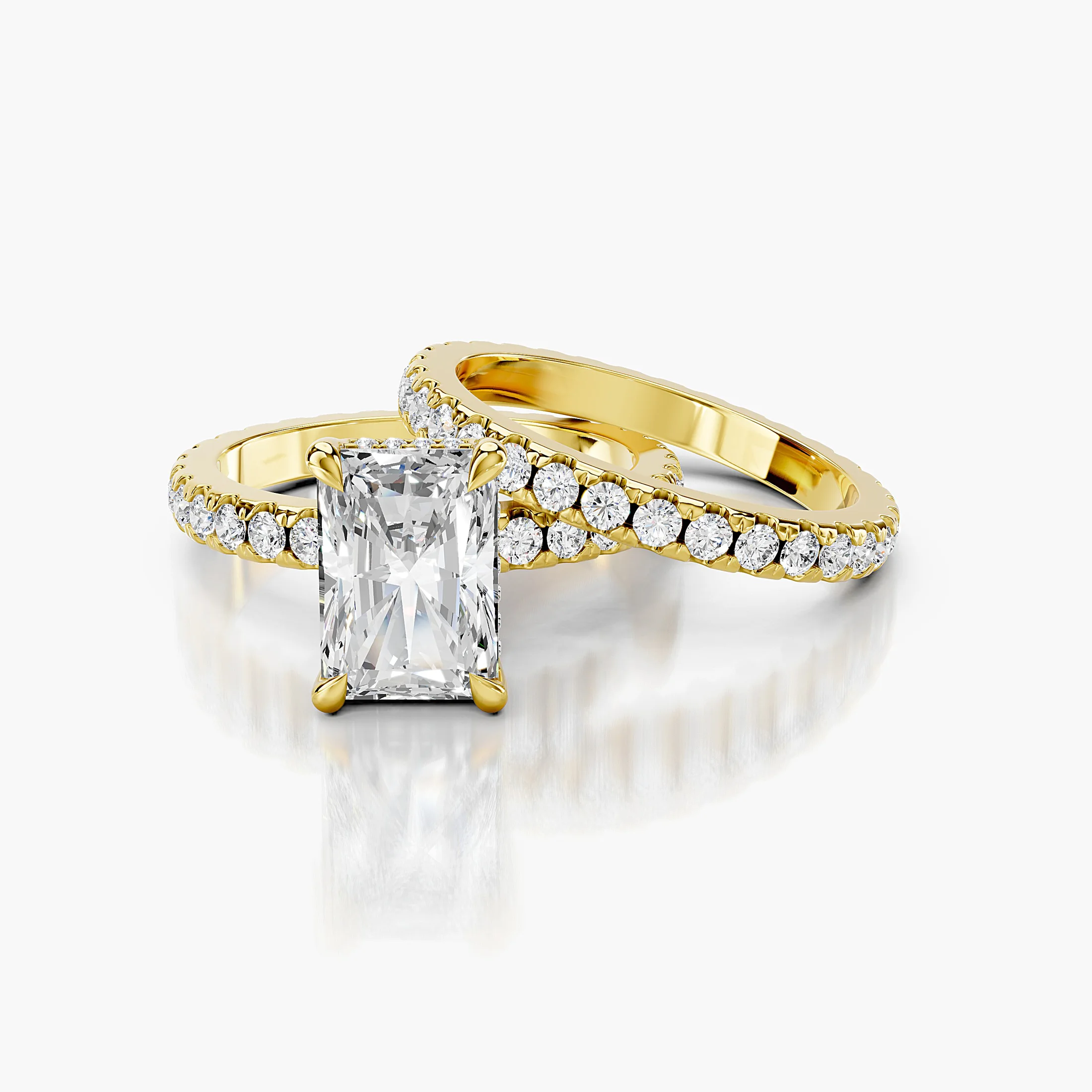 Radiant-cut hidden halo side-stone engagement ring with a coordinating straight diamond band shown as a two-piece bridal set